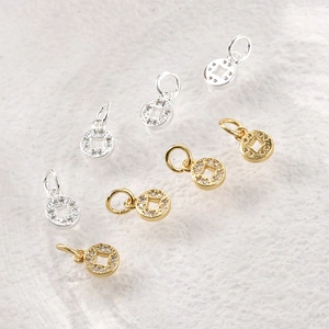 Macro detail of gold and silver coin pendants with sparkling zircon stones for DIY jewelry