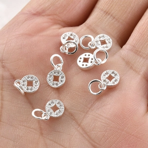 Silver coin pendant with micro-paxed zircons held in hand to show scale for jewelry making