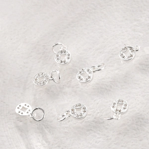 Macro view of silver ancient coin pendants with white zircons for jewelry making