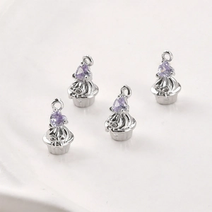 Détail de breloques cupcake en argent avec zircon violet en forme de cœur et nœud