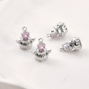 Gros plan de pendentifs gâteau plaqués or 14 carats avec zircons roses et violets en étoile