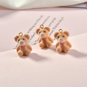 Detailed view of three mini plush flocked brown bears with pink bows for DIY jewelry