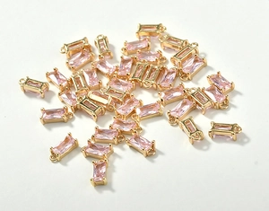 Macro shot of rectangular pink crystal glass charms with 18k gold plated copper frames