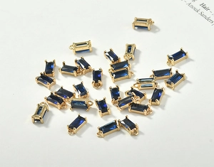 Macro view of rectangular blue crystal pendants with 18k gold-plated metal settings for DIY