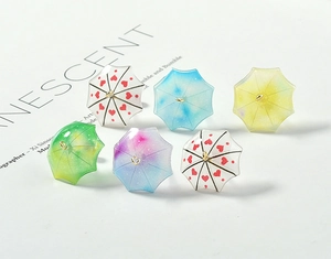 Macro shot of colorful gradient acrylic mini umbrella charms with golden hooks for jewelry making