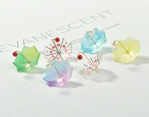 Detail of colorful acrylic umbrella charms with glitter and pearls for jewelry making