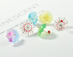 Macro detail of acrylic gradient umbrella charms for DIY earring crafts and jewelry