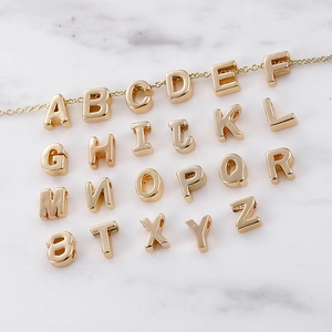 18k vergoldete Alphabet Buchstabenanhänger für DIY-Halsketten auf weißem Marmor
