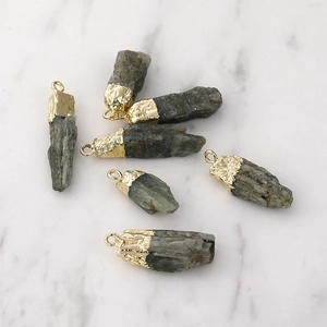 Colgante de cuarzo verde natural con borde dorado y superficie de piedra rugosa