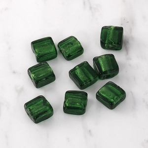 Close-up of translucent emerald green square glass beads with silver foil inside for jewelry