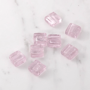 Macro shot of 8 light pink square glass beads with textured ridges for jewelry DIY