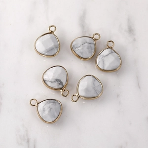 Detailed close-up of six teardrop stone charms with gold trim for DIY jewelry making