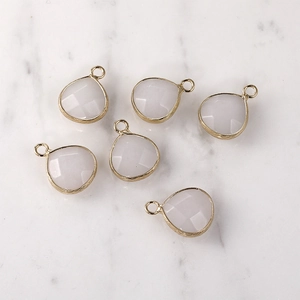 Detailed view of faceted drop-shaped crystal pendants with gold edges for jewelry DIY