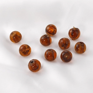 Ten amber translucent round beads with hole for DIY jewelry making on white satin
