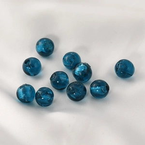 Blue glass beads with silver foil inlay for DIY jewelry making on white satin backdrop