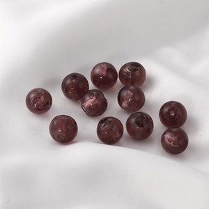 Detailed view of dark purple translucent glass beads with internal marble swirl texture
