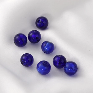 Detailed view of dark blue glass beads with silver foil texture for DIY jewelry making