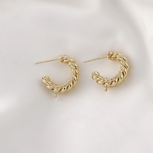 Primer plano de pendientes de aro C trenzados en oro de 14k con poste de plata S925