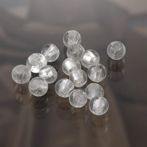 Macro shot of clear round glass beads with central drill holes for DIY jewelry making