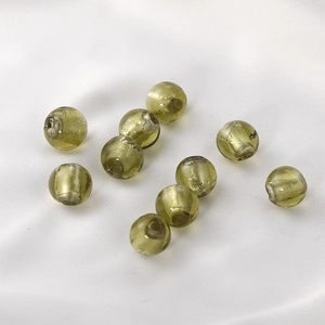 Macro shot of 9 olive green translucent glass beads on white satin for jewelry making