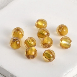 Macro shot of amber glass beads with gold foil foil inclusions for DIY jewelry making