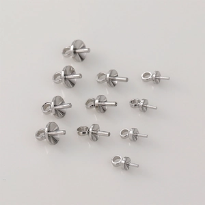 Detailed view of silver-colored DIY jewelry peg bails and bead caps for pearl pendants