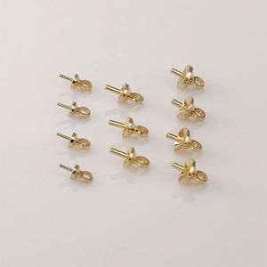 Close-up of 10 gold-plated peg bails for DIY pearl jewelry making projects