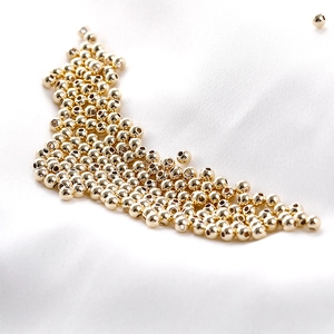 Polished 14K gold plated loose beads for DIY jewelry making on white silk fabric