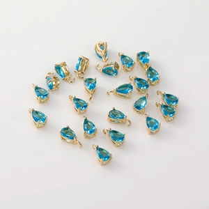 Vista macro de dijes de circón azul chapados en oro 14K para creación de joyería