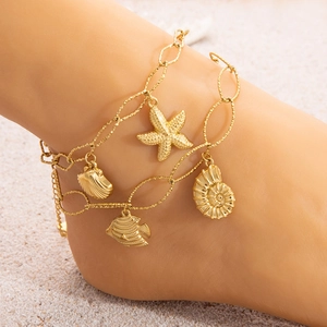 Detail of 18K gold plated anklet featuring starfish, seashell, and tropical fish charms