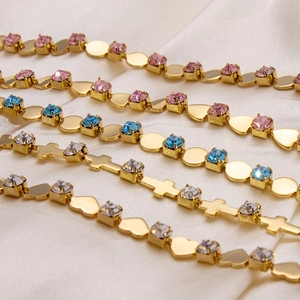 Macro detail of 18K gold-plated stainless steel bracelets with zircon charms on silk