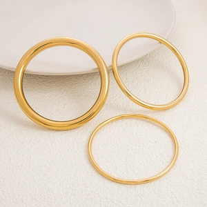 Juego de tres brazaletes de acero inoxidable bañados en oro de 18K con diferentes anchos