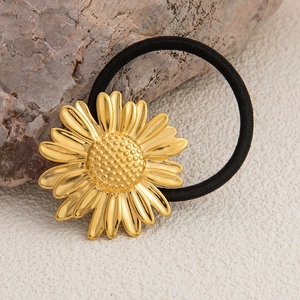 Detailaufnahme von goldenem Sonnenblumen-Haargummi mit schwarzem, hochelastischem Band
