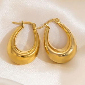 Close-up of thick 18k gold plated drop-shaped hoop earrings on elegant silk fabric