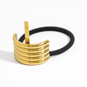 Detail der goldenen Metall-Haarklammer mit Wellenstruktur und schwarzem elastischem Band