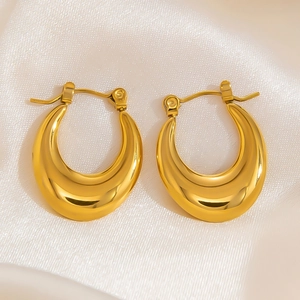 Macro shot of 18k gold plated stainless steel chunky hoop earrings on white silk fabric