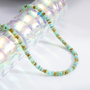 Détail du collier de perles avec disques vert clair et entretoises hexagonales dorées