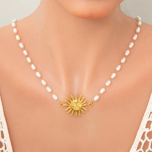 Perlenhalskette mit goldenem Sonnenanhänger an einem Model für einen schicken Stil