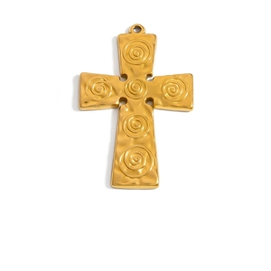 Dettaglio di un ciondolo a croce placcato oro 18k con trame a spirale e finitura martellata