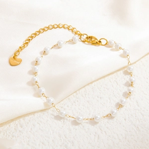 Détail du bracelet en perles d'acier inoxydable doré avec breloque cœur et fermoir