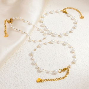 Détail d'un ensemble de trois bracelets en perles avec chaînes dorées et cœurs