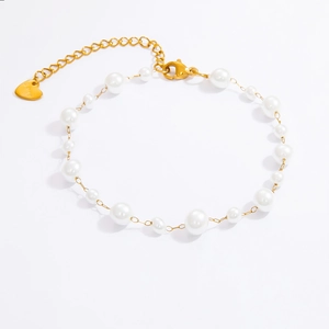 Gros plan d'un bracelet en perles avec pendentif cœur doré et fermoir ajustable