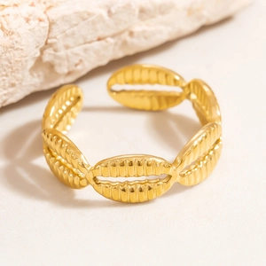 Dettaglio dell'anello dorato a forma di conchiglia su sfondo di pietra arenaria