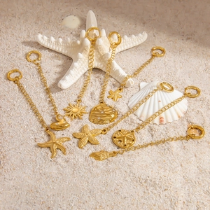 Golden ocean series pendants featuring starfish and seashell designs on sandy beach