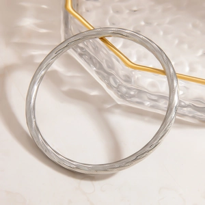 Detailed view of silver stainless steel twisted bracelet with engraved spiral patterns