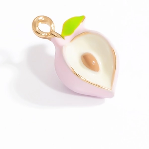Vue détaillée du pendentif pêche avec émail rose et bordure dorée élégante