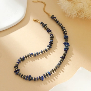 Detail van de blauwe lapis kralenketting met onregelmatige stenen en gouden sluiting