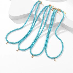 Set di 4 collane di perle turchesi con ciondoli a lettera dorati con cristalli I J K L