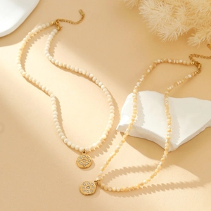 Detail van schelpparelkettingen met goudkleurige hangers met diamanten en verstelbare sluiting