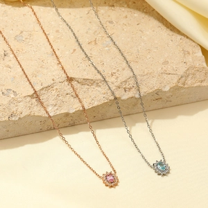 Dettaglio di collane a girasole in oro rosa e argento con gemme rosa e blu